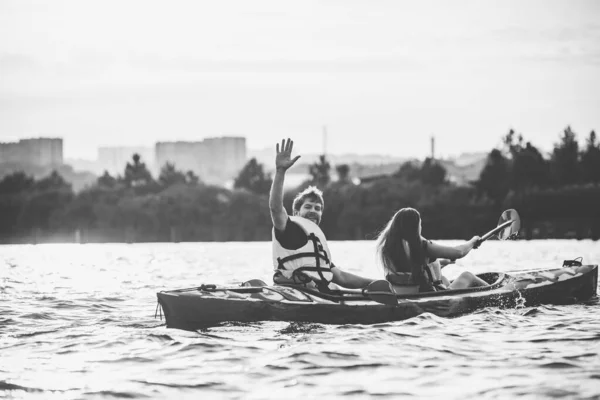 Pareja feliz kayak en el río con puesta de sol en el fondo —  Fotos de Stock