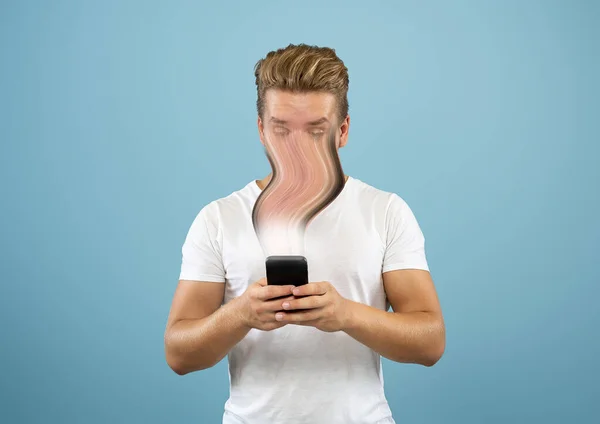Junger Mann von Gadget und sozialen Medien isoliert auf blauem Hintergrund engagiert — Stockfoto