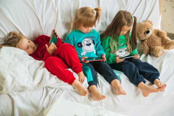 Evde oynayan yumuşak pijamalı küçük kızlar.