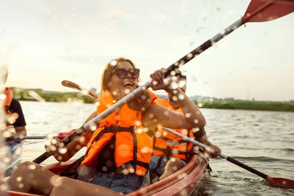 Felices amigos kayak en el río con puesta de sol en el fondo —  Fotos de Stock