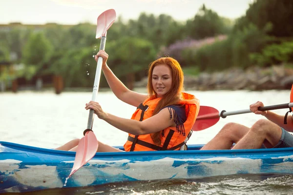 Femme caucasienne kayak sur la rivière avec coucher de soleil sur le fond — Photo