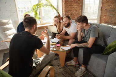 Bir grup Kafkasyalı genç ofis çalışanı yeni fikirleri tartışmak için yaratıcı bir toplantı yapıyorlar.