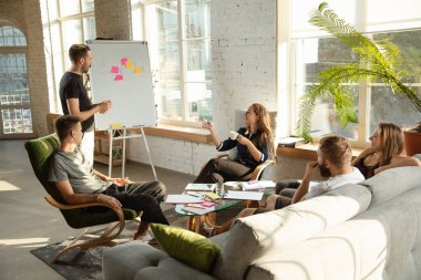 Bir grup Kafkasyalı genç ofis çalışanı yeni fikirleri tartışmak için yaratıcı bir toplantı yapıyorlar.