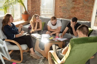 Bir grup Kafkasyalı genç ofis çalışanı yeni fikirleri tartışmak için yaratıcı bir toplantı yapıyorlar.