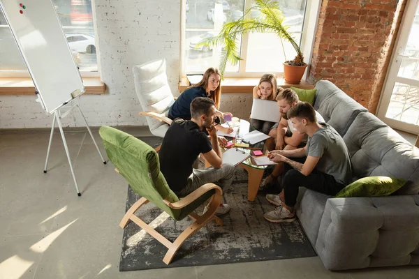 Group of young caucasian office workers have creative meeting to discuss new ideas