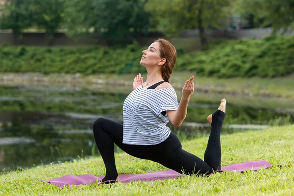 Genç ve güzel bir kadın Green Park 'ta yoga egzersizi yapıyor. Sağlıklı yaşam tarzı ve uygunluk kavramı. — Stok fotoğraf