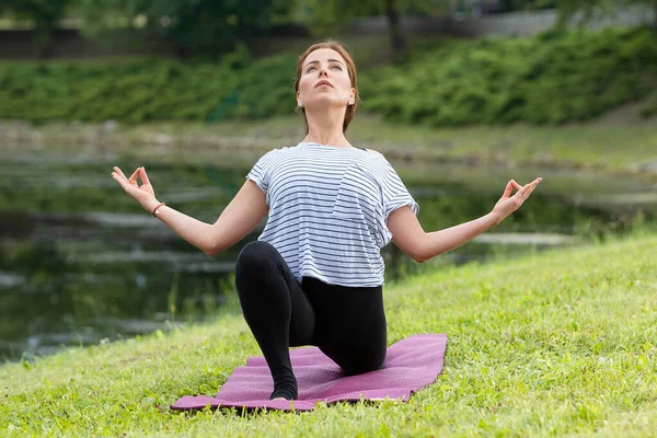 Genç ve güzel bir kadın Green Park 'ta yoga egzersizi yapıyor. Sağlıklı yaşam tarzı ve uygunluk kavramı. — Stok fotoğraf