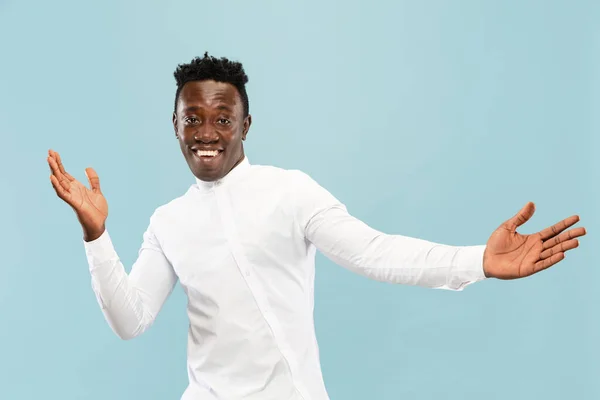 Jovem homem afro-americano isolado em fundo de estúdio azul, conceito de emoções humanas . — Fotografia de Stock