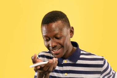 Genç Afro-Amerikalı adam sarı stüdyo arka planında izole edilmiş, insan duyguları konsepti..