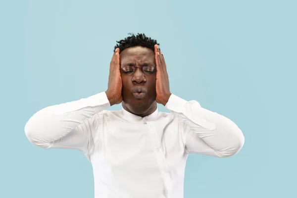 Hombre afroamericano joven aislado en fondo de estudio azul, concepto de emociones humanas . — Foto de Stock