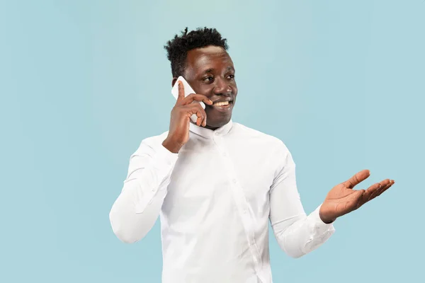 Hombre afroamericano joven aislado en fondo de estudio azul, concepto de emociones humanas . — Foto de Stock