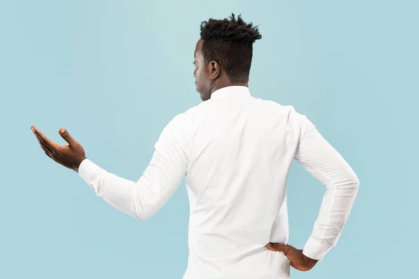 Jovem homem afro-americano isolado em fundo de estúdio azul, conceito de emoções humanas . — Fotografia de Stock