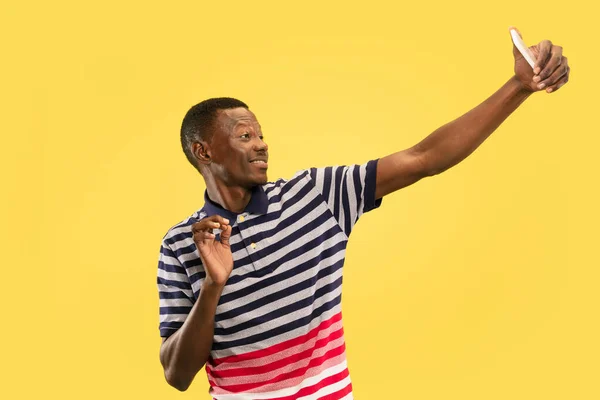 Молодий афроамериканський чоловік ізольований на жовтому фоні студії, концепція людських емоцій . — стокове фото