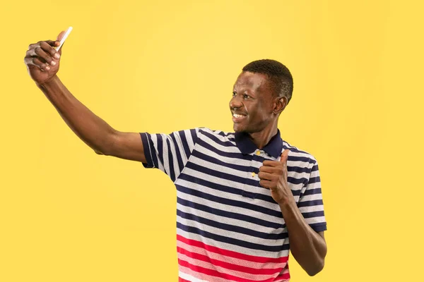 Jeune homme afro-américain isolé sur fond jaune studio, concept des émotions humaines . — Photo