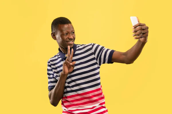 Jeune homme afro-américain isolé sur fond jaune studio, concept des émotions humaines . — Photo