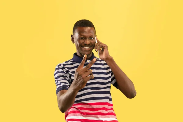 Jeune homme afro-américain isolé sur fond jaune studio, concept des émotions humaines . — Photo