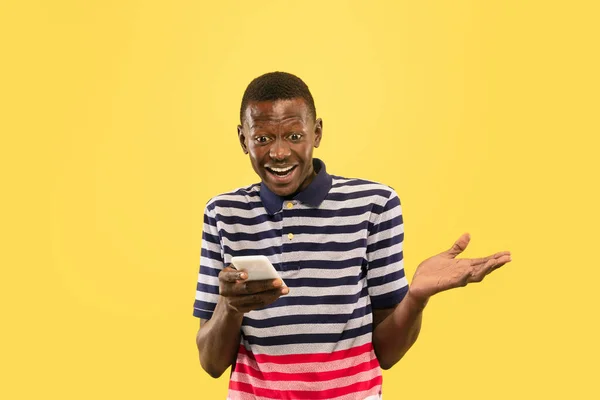 Joven afroamericano aislado sobre fondo de estudio amarillo, concepto de emociones humanas . — Foto de Stock