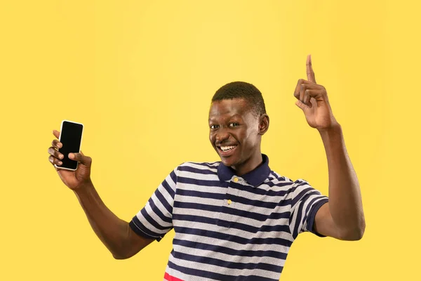 Joven afroamericano aislado sobre fondo de estudio amarillo, concepto de emociones humanas . — Foto de Stock