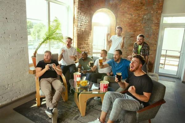 Groep opgewonden vrienden spelen van videospellen thuis — Stockfoto