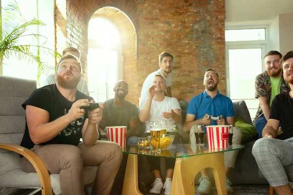 Groep opgewonden vrienden spelen van videospellen thuis — Stockfoto