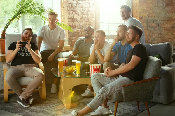 Grupo de amigos assistindo tv, jogo, campeonato, jogos de esporte. homens e  mulheres emocionais torcendo pelo jogador de tênis de mesa favorito na  américa com bandeira. conceito de amizade, esporte, competição.