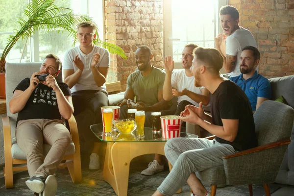 Grupo de amigos emocionados jugando videojuegos en casa —  Fotos de Stock