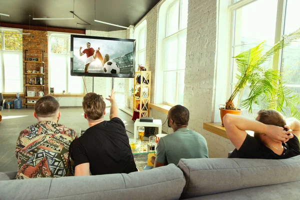 Groupe d'amis regardant le football ou le match de football à la télévision à la maison — Photo