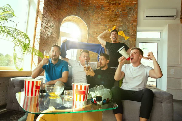 Groep vrienden die thuis voetbal of voetbal kijken op TV — Stockfoto