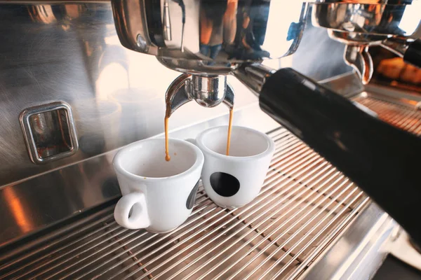 Stilvolle schwarze Espressomaschine, die zwei Tassen Kaffee braut, gedreht im Café. — Stockfoto
