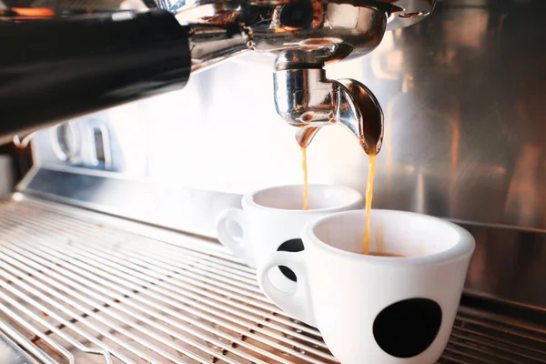 おしゃれな黒エスプレッソマシンが2杯のコーヒーを淹れ、カフェで撮影. — ストック写真