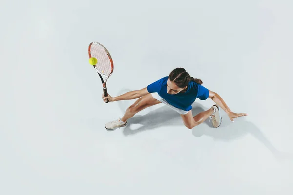 O tânără cu cămaşă albastră jucând tenis. Tineret, flexibilitate, putere și energie . — Fotografie, imagine de stoc