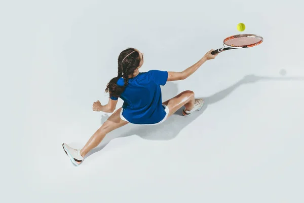 Молода жінка в блакитній сорочці грає в теніс. Молодь, гнучкість, влада та енергія . — стокове фото