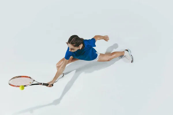 Młoda kobieta w niebieskiej koszuli gra w tenisa. Młodzież, elastyczność, siła i energia. — Zdjęcie stockowe