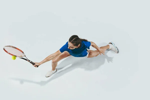 Młoda kobieta w niebieskiej koszuli gra w tenisa. Młodzież, elastyczność, siła i energia. — Zdjęcie stockowe