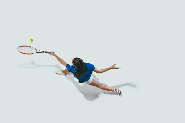 Νεαρή γυναίκα με μπλε πουκάμισο που παίζει τένις. Νεολαία, ευελιξία, δύναμη και ενέργεια. — Φωτογραφία Αρχείου