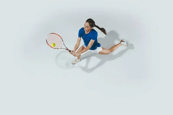 Mavi gömlekli genç bayan tenis oynuyor. Gençlik, esneklik, güç ve enerji. — Stok fotoğraf