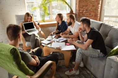 Bir grup Kafkasyalı genç ofis çalışanı yeni fikirleri tartışmak için yaratıcı bir toplantı yapıyorlar.