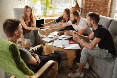 Bir grup Kafkasyalı genç ofis çalışanı yeni fikirleri tartışmak için yaratıcı bir toplantı yapıyorlar.