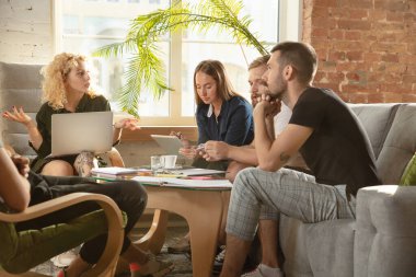 Bir grup Kafkasyalı genç ofis çalışanı yeni fikirleri tartışmak için yaratıcı bir toplantı yapıyorlar.