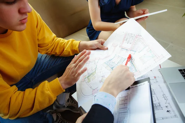 Innenarchitektin bei der Arbeit mit jungen Paaren. schöne Familie und professioneller Designer oder Architekt. — Stockfoto