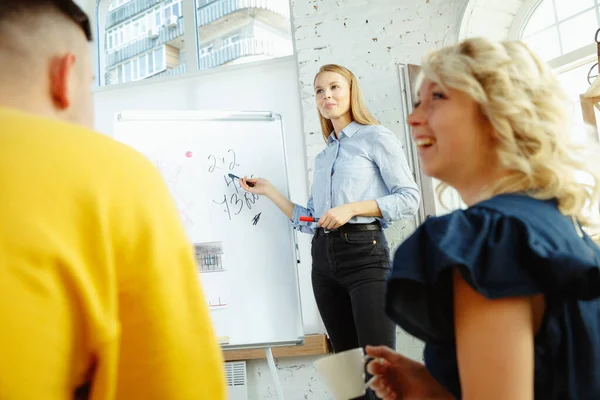 Diseñador de interiores trabajando con parejas jóvenes. Precioso diseñador familiar y profesional o arquitecto . — Foto de Stock