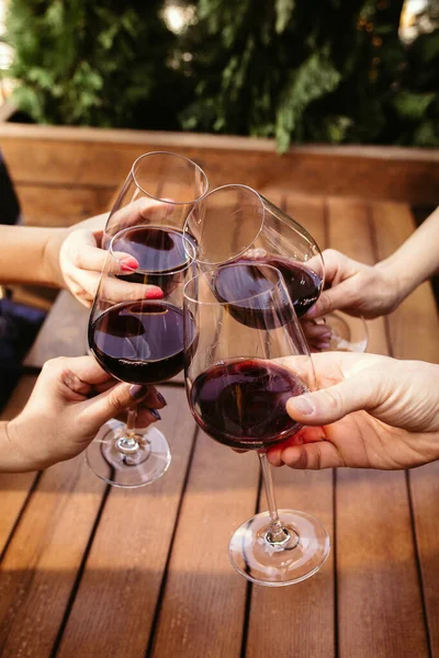 Mensen klappen glazen met wijn op het zomerterras van café of restaurant. close-up shot, levensstijl. — Stockfoto