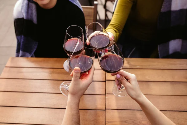 People clinking glasses with wine on the summer terrace of cafe or restaurant. Close up shot, lifestyle. — Stock Photo, Image