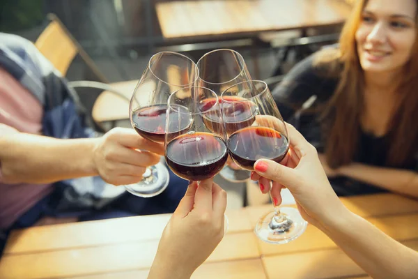 Les gens cliquetis verres avec du vin sur la terrasse d'été du café ou un restaurant. Gros plan, mode de vie . — Photo