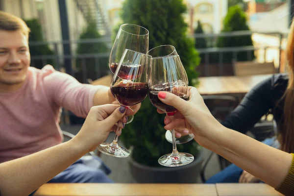 Menschen, die auf der Sommerterrasse eines Cafés oder Restaurants Gläser mit Wein klappern. Nahaufnahme, Lebensstil. — Stockfoto