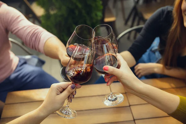 Люди звонят бокалы с вином на летней террасе кафе или ресторана. Крупный план, стиль жизни . — стоковое фото