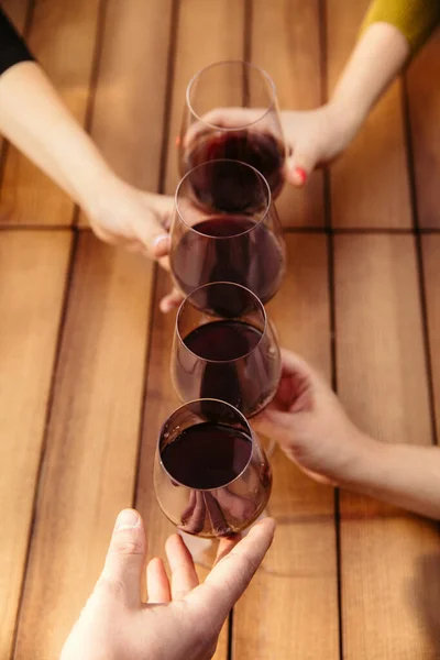 Menschen, die auf der Sommerterrasse eines Cafés oder Restaurants Gläser mit Wein klappern. Nahaufnahme, Lebensstil. — Stockfoto