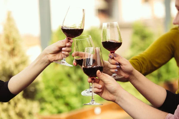 Az emberek poharakat csörömpölnek borral a kávézó vagy étterem nyári teraszán. Közelkép, életmód.. — Stock Fotó
