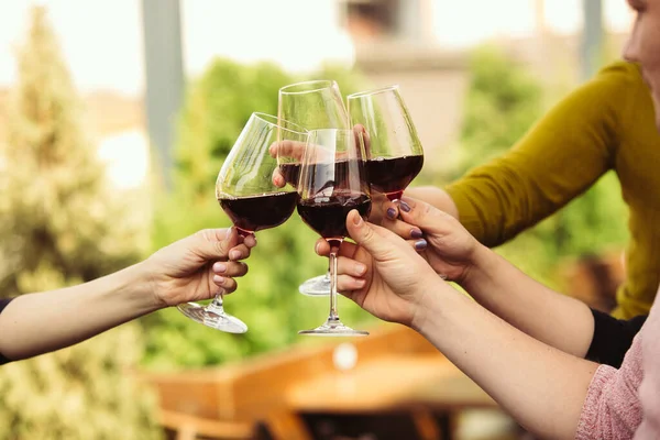 Az emberek poharakat csörömpölnek borral a kávézó vagy étterem nyári teraszán. Közelkép, életmód.. — Stock Fotó