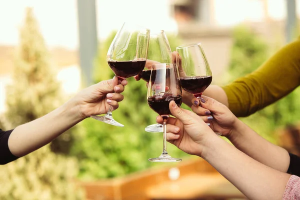 People clinking glasses with wine on the summer terrace of cafe or restaurant. Close up shot, lifestyle. — Stock Photo, Image